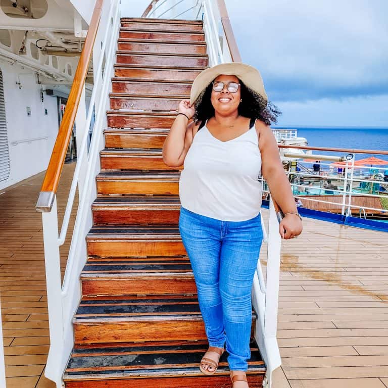 A woman standing on the stairs of a cruise ship.