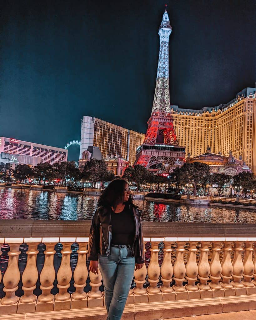 A woman standing in front of a large building.