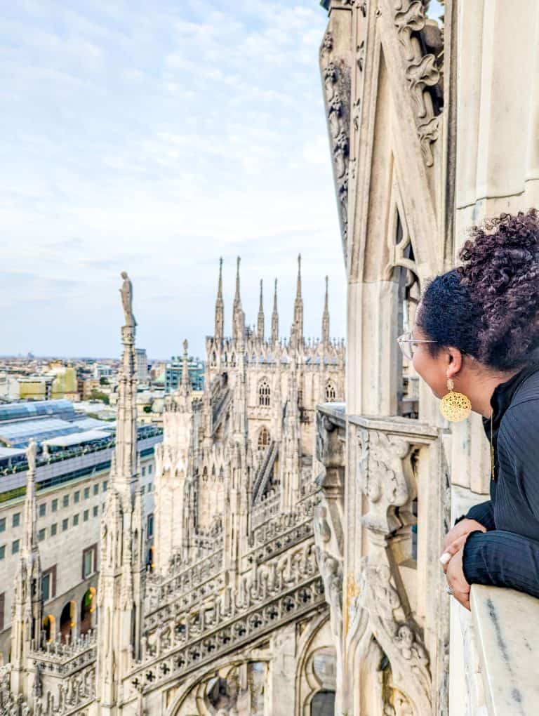 A woman looking out the window of a cathedral in milan.