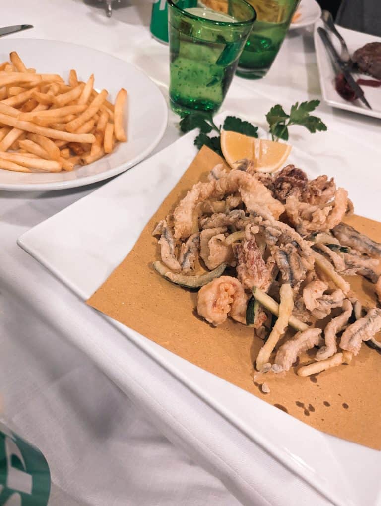 A plate of fish and fries on a table.