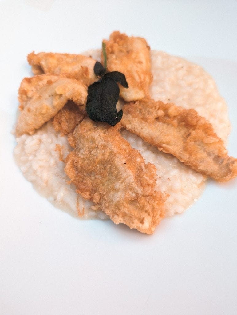 A white plate with fish and rice on it.