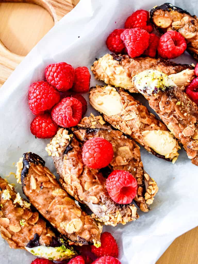 A sheet of paper with a bunch of raspberries and pistachios on it.