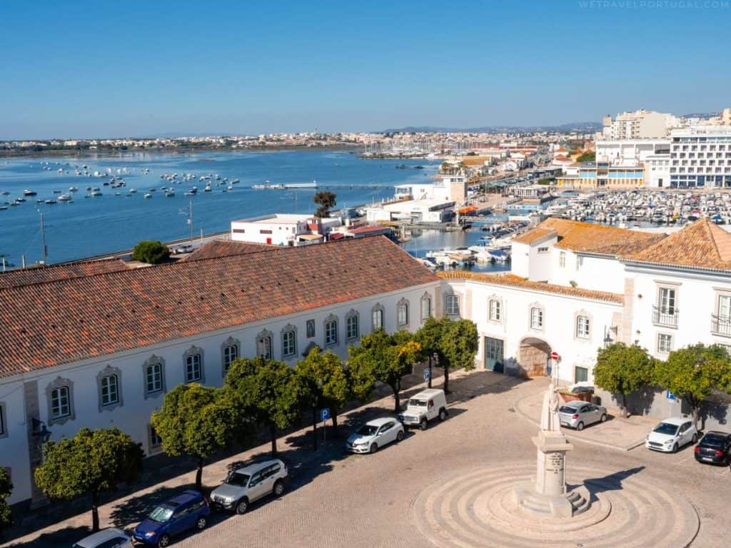 An aerial view of a city with a harbor and cars parked around it, showcasing 