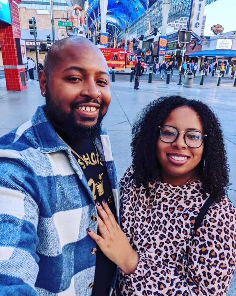 A man and woman posing for a selfie in a city.