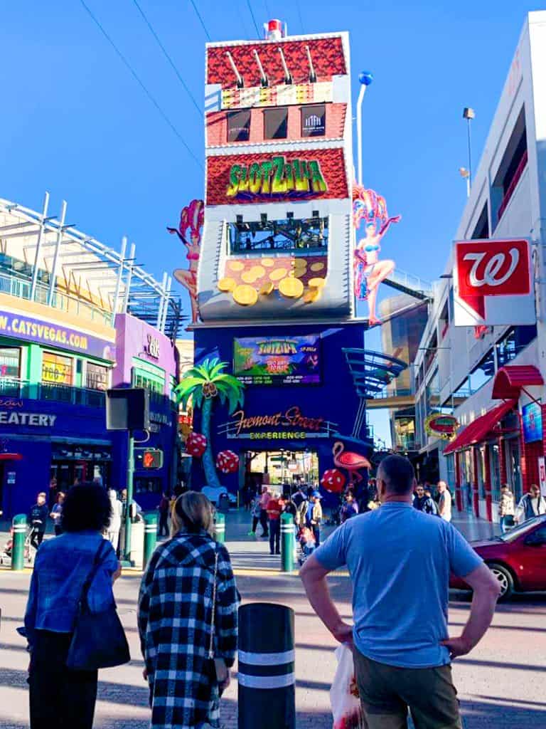 A group of people walking down a street in a city.