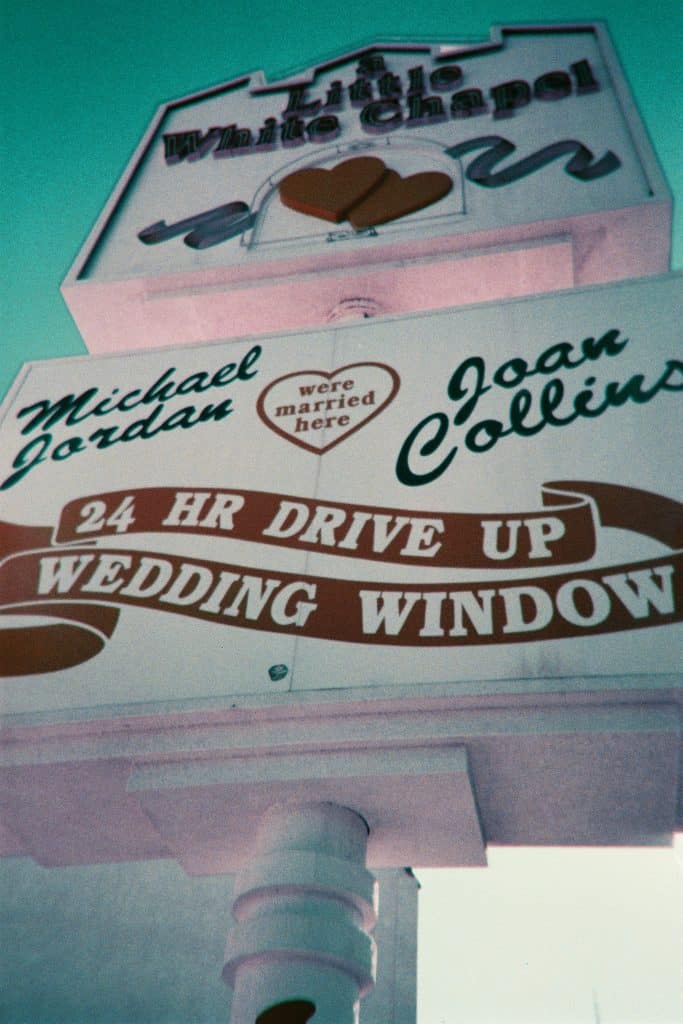 Signage for a 24-hour drive-up wedding window at a chapel, indicating that both michael jordan and joan collins were married there.