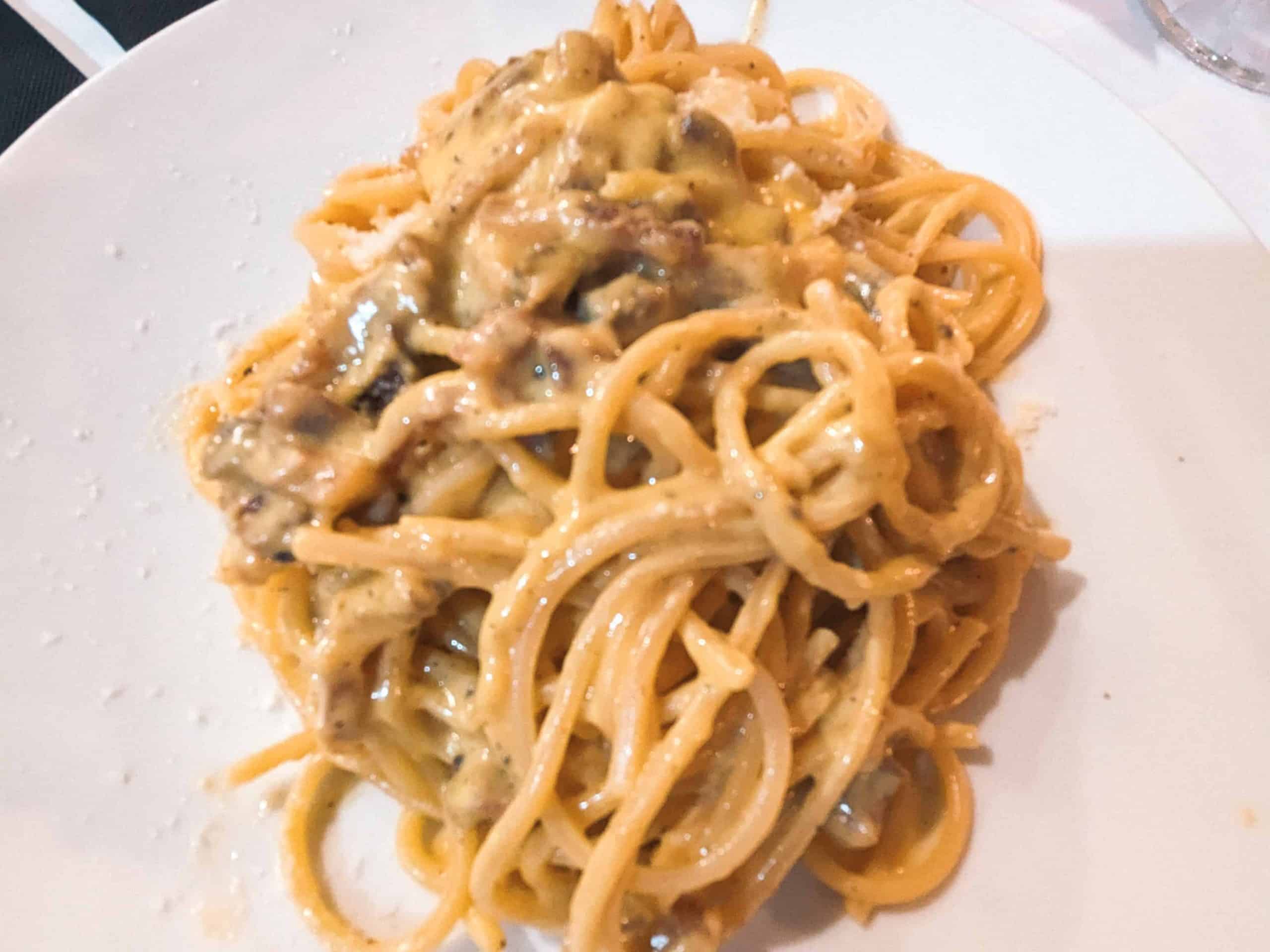 A plate of spaghetti with mushrooms on it.